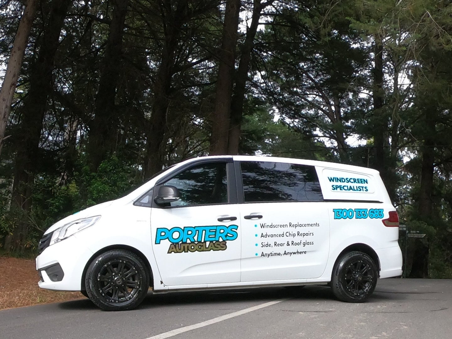 White van on a road with trees in the background The van is labeled "PORTERS AUTOGLASS" and lists services such as windscreen replacements and chip repairs The contact number " " is visible